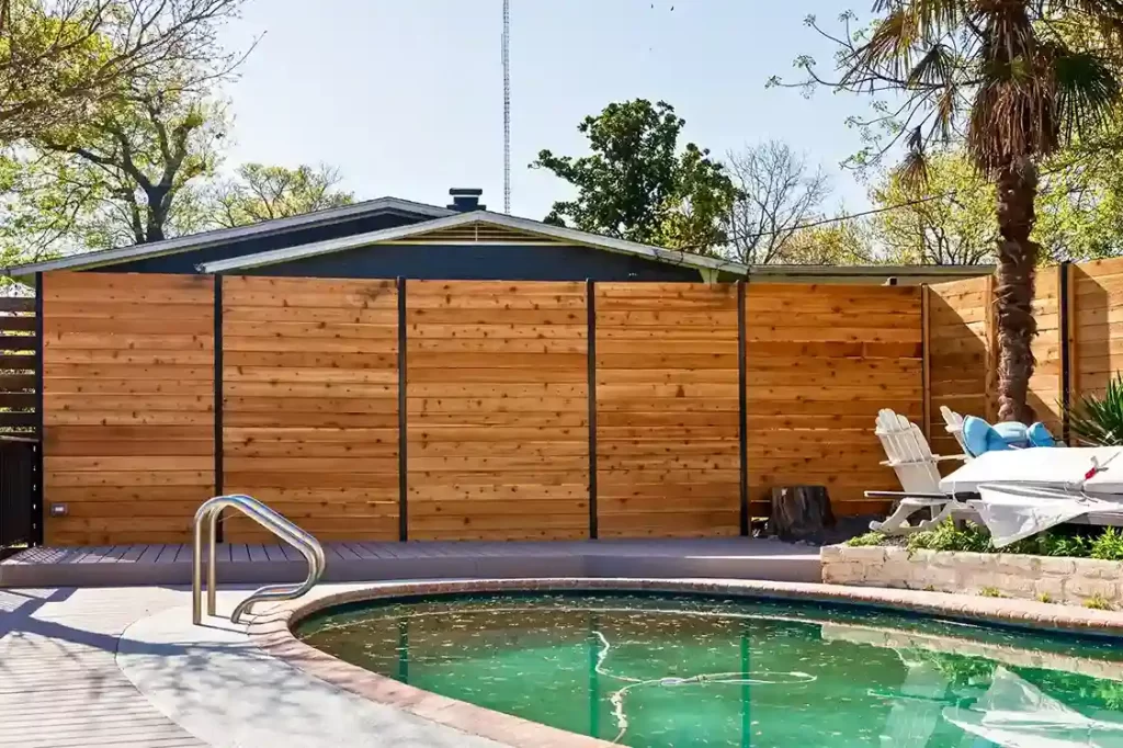 stained wood privacy fence beside residential pool in Austin